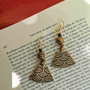 Σκουλαρίκια κρεμαστά με δύο χρυσαφί χάντρες και εμπριμέ στολίδι.