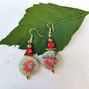 Σκουλαρίκια με κόκκινη χάντρα και πολύχρωμο λουλούδι.